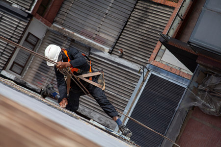 rope secured worker hangs from the building