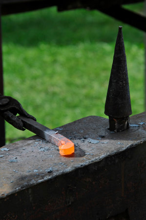 blacksmith working with hot metal on the anvil at a forgeの写真素材