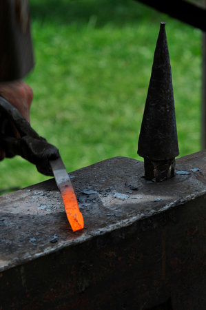 blacksmith working with hot metal on the anvil at a forgeの写真素材