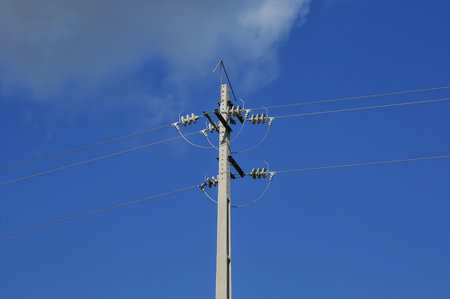 Electricity pylon against the blue sky, closeup of photoの写真素材