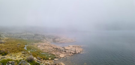 Idyllic landscape of a lagoon in a foggy environment, in Lagoa Comprida, Serra da Estrela, Portugalの写真素材