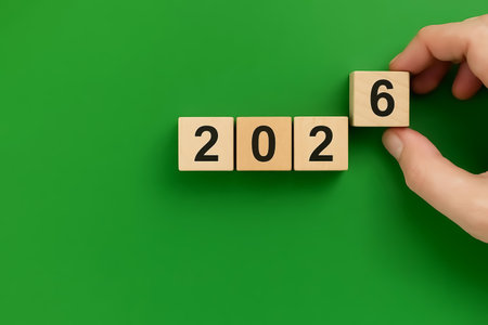 Wooden cubes spelling the word 2026, a hand completes the word. Ecology concept and New Yearの素材