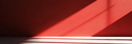 An abstract play of shadows and light dances on a bold red wall, creating captivating visual interest and allureの素材