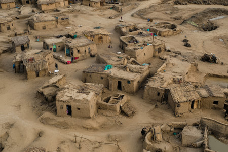 This aerial view captures the essence of a traditional African mud village, showcasing functional mud homes and the challenging living conditions faced by its resilient inhabitantsの素材