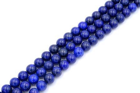 Blue lapis lazuli natural stone round shape bead isolated on white backgroundの写真素材