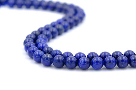 Blue lapis lazuli natural stone round shape bead isolated on white backgroundの写真素材