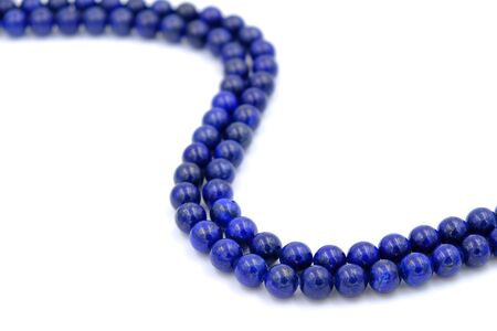 Blue lapis lazuli natural stone round shape bead isolated on white backgroundの写真素材