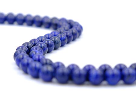Blue lapis lazuli natural stone round shape bead isolated on white backgroundの写真素材
