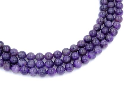 Purple amethyst natural stone round shape bead isolated on white backgroundの写真素材