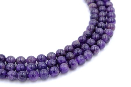 Purple amethyst natural stone round shape bead isolated on white backgroundの写真素材