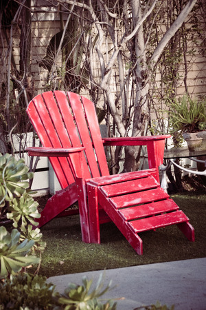 Red wooden vintage beach chair in the gardenの写真素材