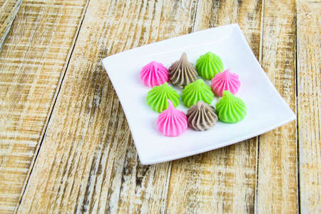 Candy in white plate on the wooden background.の写真素材