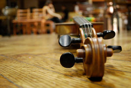 Photo of the Violin Musical Instrument Lying on a Wooden Floorの写真素材