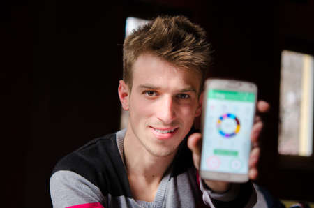 Photo of the The young man shows his financial balance on your mobile phone