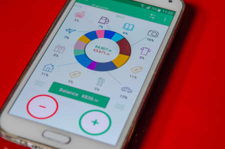 Photo of the Morning coffee on a red table with a review of the financial positionの写真素材