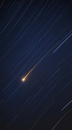 A long exposure of stars in the night sky showing star trails and a meteorの素材