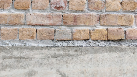 Close up shot of a brick wall with concrete foundation in natural light