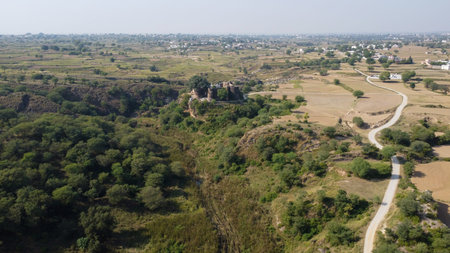 Aerial view of Sangni Fort surrounded by forest on one side and village farmland on the other showing Pakistan heritageの写真素材