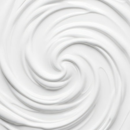A detailed image showcasing a swirling pattern of white cosmetic cream on a white background, highlighting its texture and visual appeal.の素材