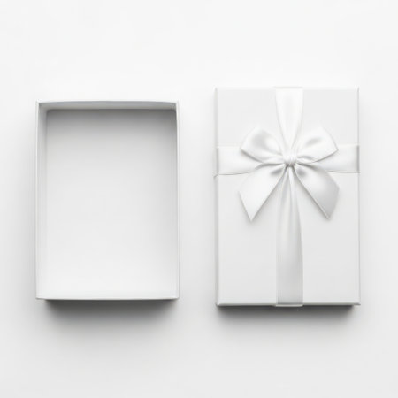 White gift box with white ribbon isolated on white background. Top view.の素材