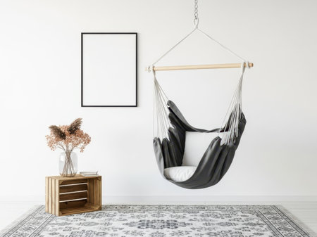 This image features a stylish hanging black hammock chair with a white pillow, suspended from a wooden frame. The chair is set against a clean white background, with a wooden side table and a vase of dried flowers on the left. A patterned rug adds texture to the floor. The overall aesthetic is modern and minimalist, perfect for showcasing the hammock chair's design.の素材