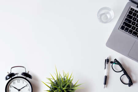 White office desk table with laptop, smartphone, and glass. Top view with copy space, flat lay.の写真素材