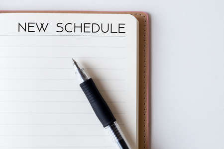 Conceptual,notebook on a white table. open diary and pen with new schedule wordsの写真素材