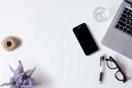 White office desk table with laptop, smartphone, lavender, rope, and glass. Top view with copy space, flat lay.の写真素材
