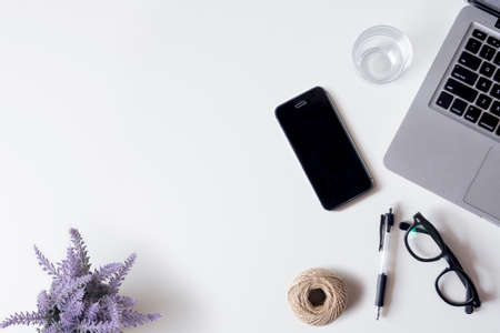 White office desk table with laptop, smartphone, lavender, rope, and glass. Top view with copy space, flat lay.の写真素材