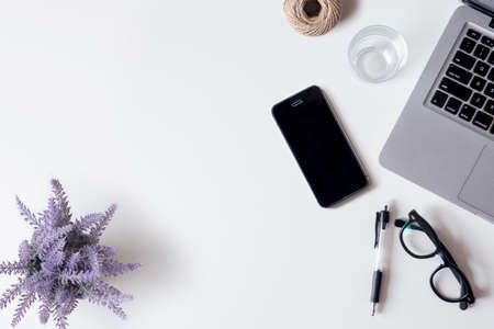 White office desk table with laptop, smartphone, lavender, rope, and glass. Top view with copy space, flat lay.の写真素材
