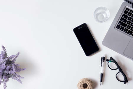 White office desk table with laptop, smartphone, lavender, rope, and glass. Top view with copy space, flat lay.の写真素材