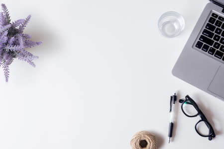 White office desk table with laptop, smartphone, pen, lavender, rope and glass. Top view with copy space, flat lay.の写真素材