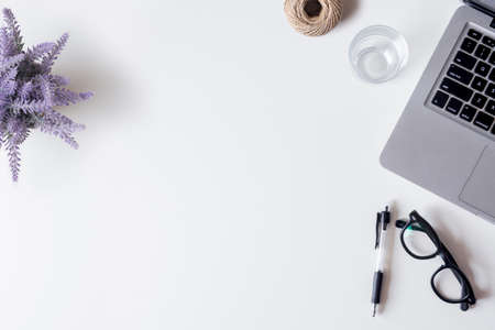 White office desk table with laptop, smartphone, pen, lavender, rope and glass. Top view with copy space, flat lay.の写真素材
