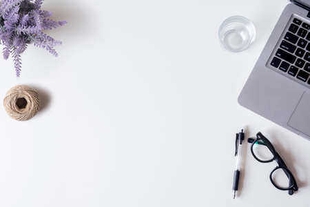 White office desk table with laptop, smartphone, pen, lavender, rope and glass. Top view with copy space, flat lay.の写真素材