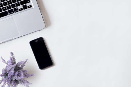 White office desk table with laptop, smartphone, and lavender. Top view with copy space, flat lay.の写真素材