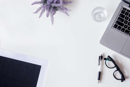 White office desk table with laptop, file, lavender, and glass. Top view with copy space, flat lay.の写真素材