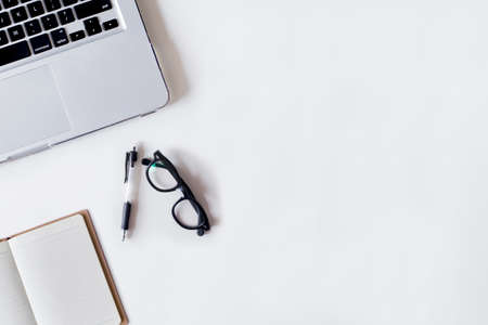 White office desk table with laptop, pen, and notebook. Top view with copy space, flat lay.の写真素材