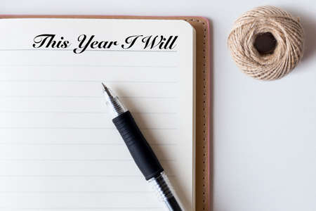Conceptual,notebook on a white table. open diary,rope, and pen with This Year I Will wordsの写真素材