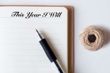 Conceptual,notebook on a white table. open diary,rope, and pen with This Year I Will wordsの写真素材