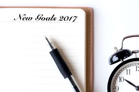 Conceptual,notebook on a white table. open diary, alarm clock and pen with New Goals 2017 wordsの写真素材