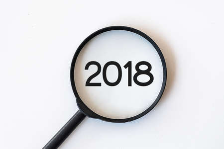 2018 word in Magnifying Glass isolated with whte backgroundの写真素材