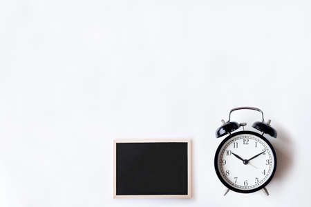 White office desk table with chalkboards and alarm clock. Top view with copy space, flat lay.の写真素材
