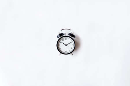 White office desk table with alarm clock. Top view with copy space, flat lay.の写真素材