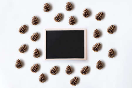 White office desk table with chalkboard and pinecones. Top view with copy space, flat lay.の写真素材