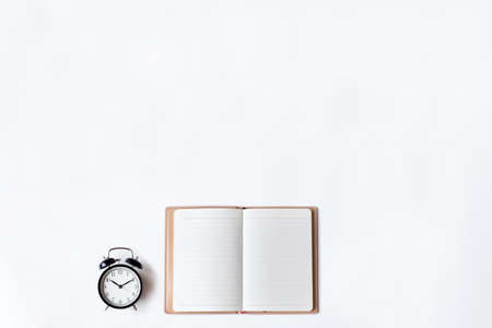 White office desk table with open diary and alarm clock, Top view with copy space, flat lay.の写真素材