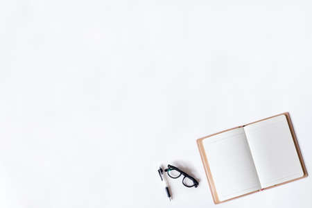 White office desk table with open diary, and glass, Top view with copy space, flat lay.の写真素材