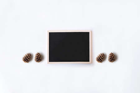 White office desk table with chalkboard and pinecones. Top view with copy space, flat lay.の写真素材