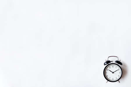 White office desk table with alarm clock. Top view with copy space, flat lay.の写真素材