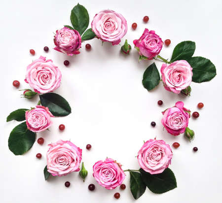 Decorative frame with pink bright roses and berries on white background. Flat layの写真素材