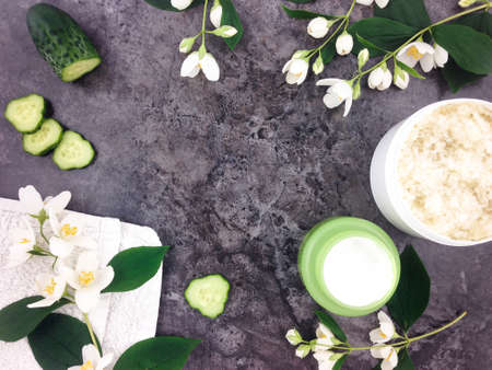 Set of spa treatment products and jasmine flowers on stone background. Flat lay